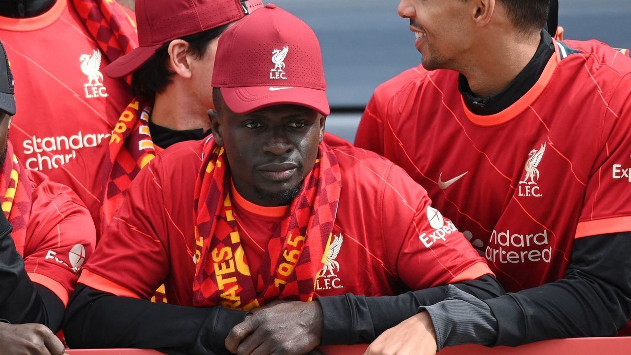 Liverpool's Senegalese striker Sadio Mane reacts as he stands among temmates on an open-top bus during a parade through the streets of Liverpool in north-west England on May 29, 2022, to celebrate winning the 2021-22 League Cup and FA Cup. - Despite the disappointment of losing to real Madrid in the final of the UEFA Champions League, Klopp has called on Liverpool fans to take to the streets of the city on Sunday when they parade the League Cup and FA Cup.