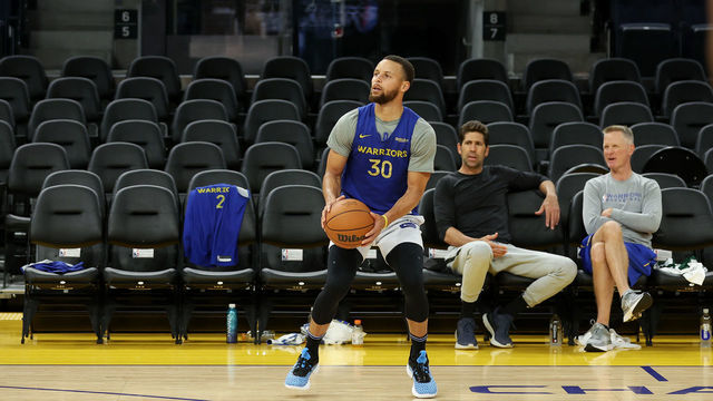SAN FRANCISCO, CALIFORNIA - JUNE 01: Stephen Curry #30 of the Golden State Warriors warms up in front of general manager Bob Myers and head coach Steve Kerr during media day prior to the start of the NBA Finals at Chase Center on June 01, 2022 in San Francisco, California. The Golden State Warriors will play the Boston Celtics in Game 1 of the NBA Finals on June 2, 2022. NOTE TO USER: User expressly acknowledges and agrees that, by downloading and/or using this photograph, User is consenting to the terms and conditions of the Getty Images License Agreement.