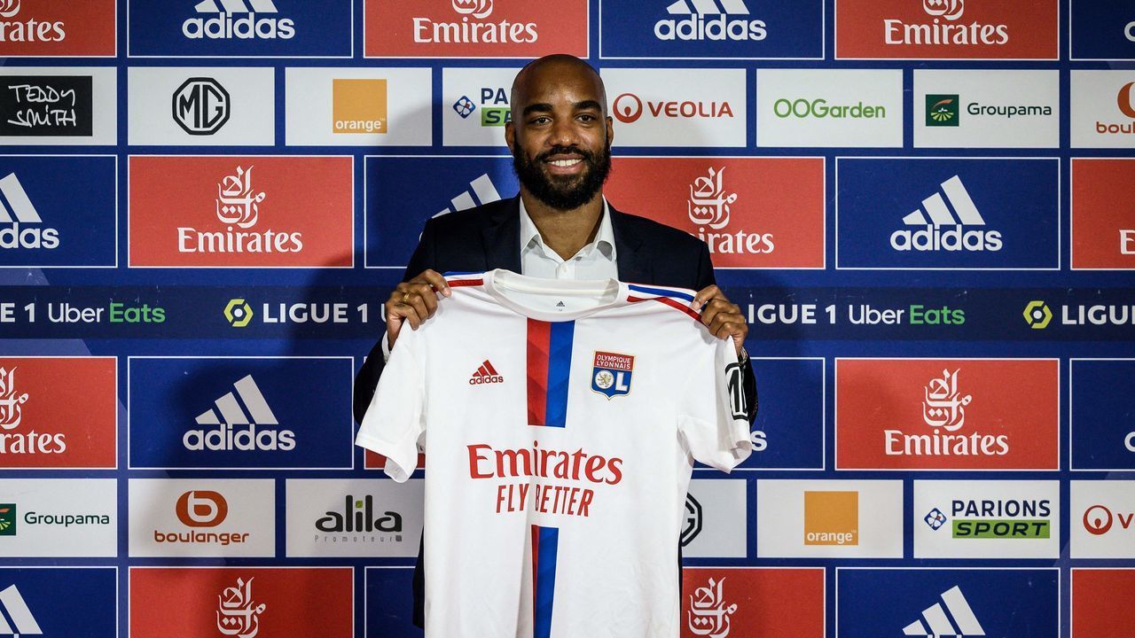 Former France international Alexandre Lacazette poses with his jersey during a press conference to announce his return to Ligue 1 Olympique Lyonnais (OL) football club, on June 9, 2022 in Decines-Charpieu, central-eastern France. - Lacazette returns to Lyon on a free transfer five years after he joined Arsenal for a then club record fee of £46.5 million ($58 million). The 31-year-old striker underwent a medical before signing a three year contract with the club where he made his name after coming through the youth system.