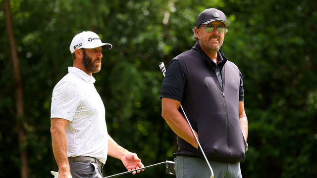 ST ALBANS, ENGLAND - JUNE 09: Dustin Johnson of 4 Aces GC greets Phil Mickelson of Hy Flyers GC look on on the 2nd green during day one of the LIV Golf Invitational - London at The Centurion Club on June 09, 2022 in St Albans, England.