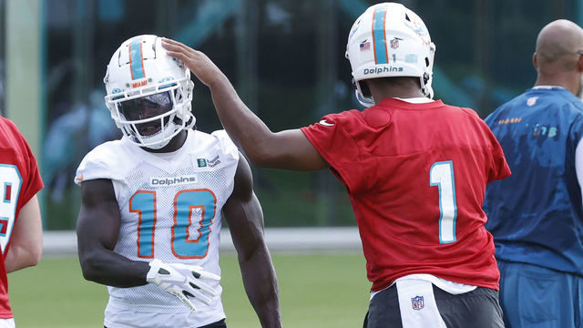 MIAMI GARDENS, FL - JUNE 1: Tua Tagovailoa #1 taps the helmet of Tyreek Hill #10 of the Miami Dolphins between drills during the Miami Dolphins Mandatory Minicamp at the Baptist Health Training Complex on June 1, 2022 in Miami Gardens, Florida.