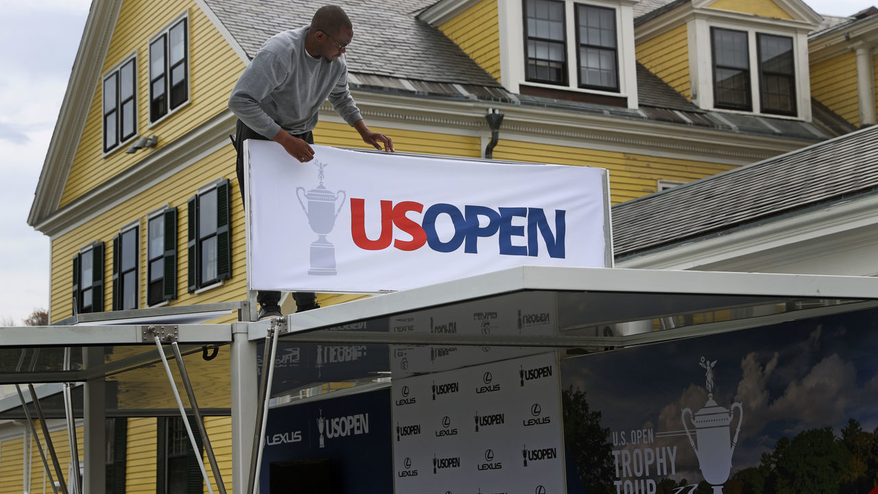Brookline, MA - May 2: Jermaine Blake, tour manager for USGA and LEXUS, sets up a sign in front of The Country Club in Brookline, MA on May 2, 2022. The US OPEN will be played at The Country Club, in June.