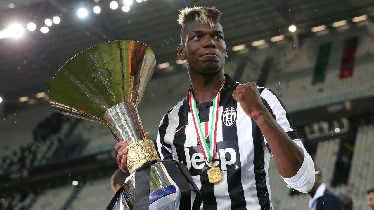 Juventus' midfielder from France Paul Pogba celebrates with the Italian League's trophy during a ceremony following the Italian Serie A football match Juventus vs Napoli on May 23, 2015 at the Juventus stadium in Turin. Juventus won the Coppa Italia on May 20, 2015 and the Italian League today after their 3-1 victory over Napoli. AFP PHOTO / MARCO BERTORELLO