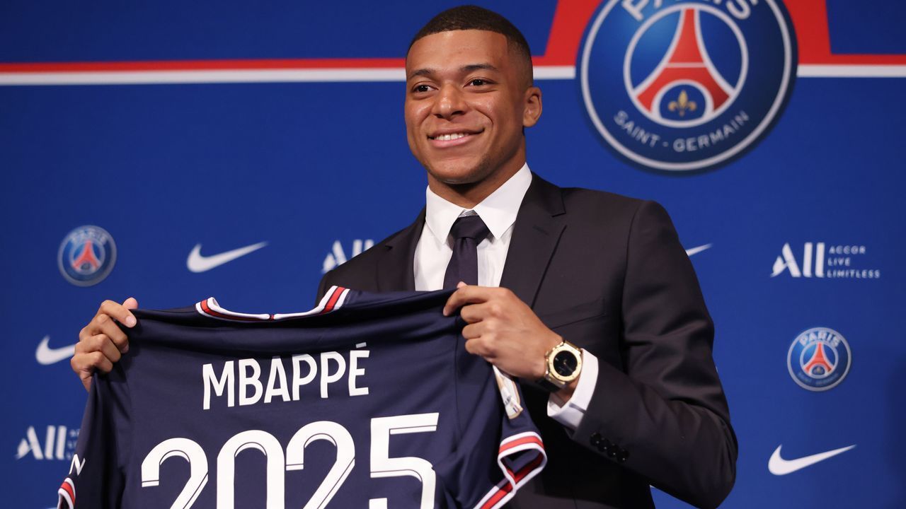 French forward Kylian Mbappe poses with a jersey at the end of a press conference at the Parc des Princes stadium in Paris on May 23, 2022, two days after the club won the Ligue 1 title for a record-equalling tenth time and its superstar striker Mbappe chose to sign a new contract until 2025 at PSG rather than join Real Madrid.
