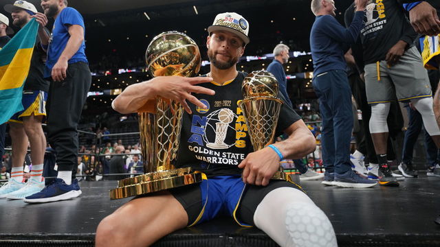 BOSTON, MA - JUNE 16: Stephen Curry #30 of the Golden State Warriors celebrates on stage with The Larry O'Brien Trophy and the Bill Russell Finals MVP Trophy after winning during Game Six of the 2022 NBA Finals on June 16, 2022 at TD Garden in Boston, Massachusetts. NOTE TO USER: User expressly acknowledges and agrees that, by downloading and or using this photograph, user is consenting to the terms and conditions of Getty Images License Agreement. Mandatory Copyright Notice: Copyright 2022 NBAE