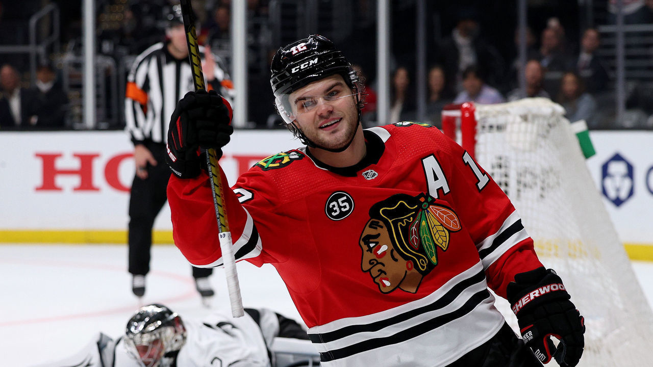 LOS ANGELES, CALIFORNIA - MARCH 24: Alex DeBrincat #12 of the Chicago Blackhawks celebrates his goal past Jonathan Quick #32 of the Los Angeles Kings, to clinch a 4-3 win in an overtime shootout at Crypto.com Arena on March 24, 2022 in Los Angeles, California.