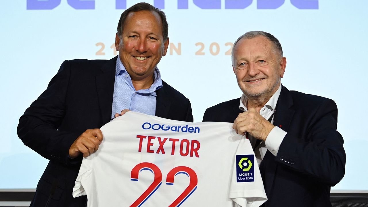 Lyon football club president Jean-Michel Aulas (R) and US businessman John Textor (L) pose at the end of a press conference to announce the sell of a major stake of the club to Textor's Eagle Football Holdings, in Decines-Charpieu, near Lyon, on June 21, 2022.