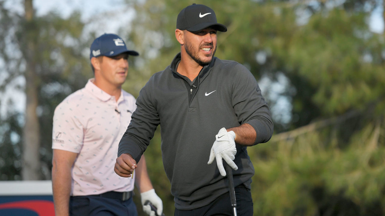 LAS VEGAS, NEVADA - NOVEMBER 26: Brooks Koepka plays his shot from the 10th tee as Bryson DeChambeau looks on during Capital One's The Match V: Bryson v Brooks at Wynn Golf Course on November 26, 2021 in Las Vegas, Nevada.