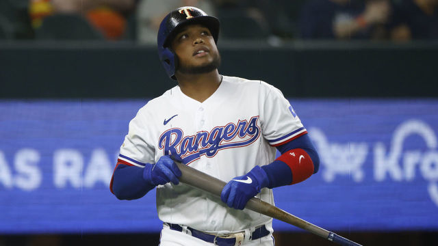 ARLINGTON, TX - APRIL 26: Willie Calhoun #4 of the Texas Rangers walks back to the dugout after striking out with the bases loaded against the Houston Astros to end the seventh inning at Globe Life Field on April 26, 2022 in Arlington, Texas.