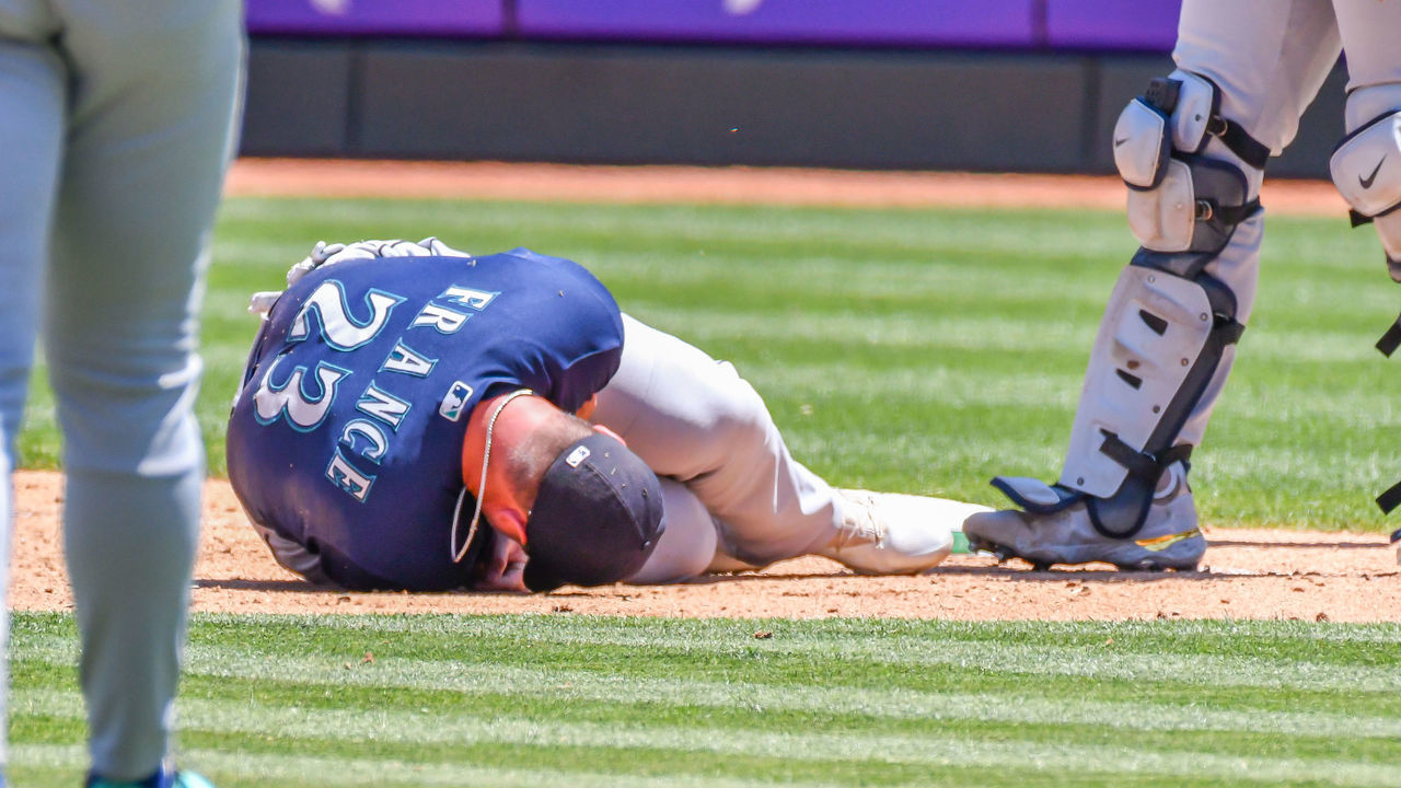 OAKLAND, CA - JUNE 23: Seattle Mariners first baseman Ty France (23) lies on the ground in pain after being struck by a throw from Seattle Mariners third baseman Abraham Toro (13) during the game between the Seattle Mariners and the Oakland Athletics on Thursday, June 23, 2022 at the Oakland Coliseum in Oakland, California.