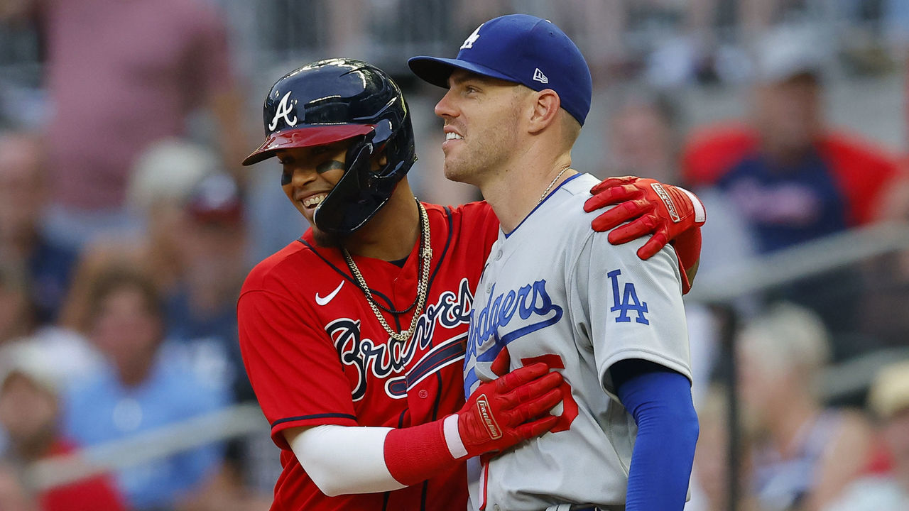 ATLANTA, GA - JUNE 24: Orlando Arcia #11 of the Atlanta Braves laughs with Freddie Freeman #5 of the Los Angeles Dodgers at first base during the third inning at Truist Park on June 24, 2022 in Atlanta, Georgia.