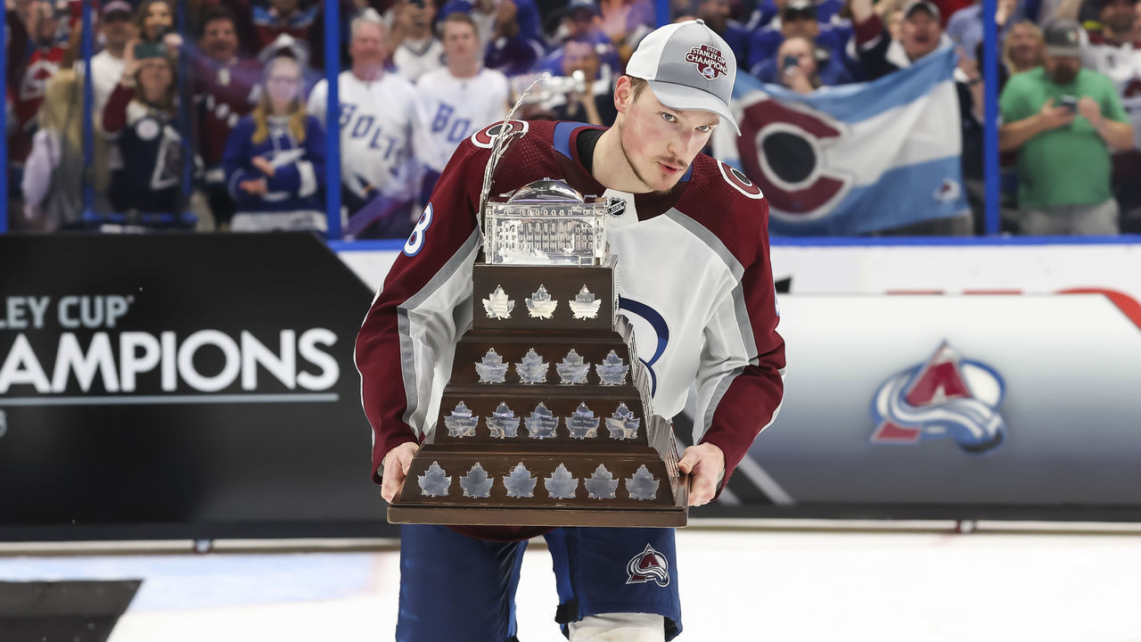 TAMPA, FL - JUNE 26: Cale Makar #8 of the Colorado Avalanche accepts the Conn Smythe trophy for Stanley Cup playoff MVP from NHL Deputy Commissioner Bill Daly after Game Six of the 2022 Stanley Cup Final at Amalie Arena on June 26, 2022 in Tampa, Florida. The Avalanche defeated the Lightning four games to two.