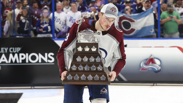 TAMPA, FL - JUNE 26: Cale Makar #8 of the Colorado Avalanche accepts the Conn Smythe trophy for Stanley Cup playoff MVP from NHL Deputy Commissioner Bill Daly after Game Six of the 2022 Stanley Cup Final at Amalie Arena on June 26, 2022 in Tampa, Florida. The Avalanche defeated the Lightning four games to two.