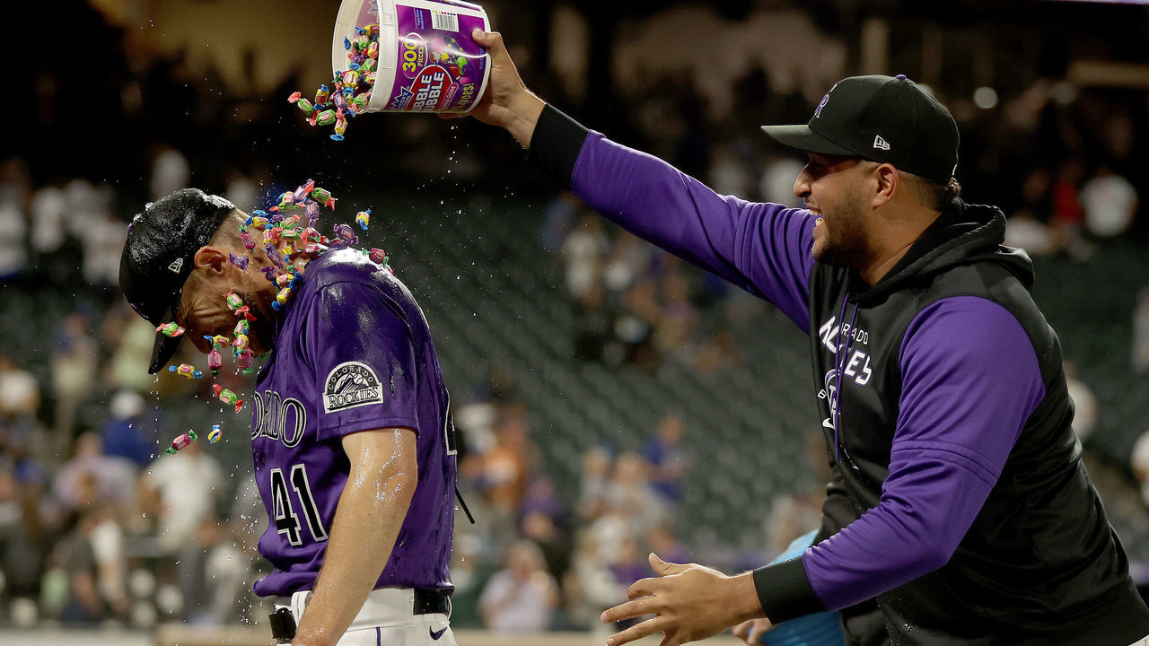 DENVER, COLORADO - JUNE 27: Starting pitcher Chad Kuhl #41 of the Colorado Rockies is douched with water and candy by Charlie Blackmon and Carlos Estevez after pitching a complete game shut out against the Los Angeles Dodgers at Coors Field on June 27, 2022 in Denver, Colorado.