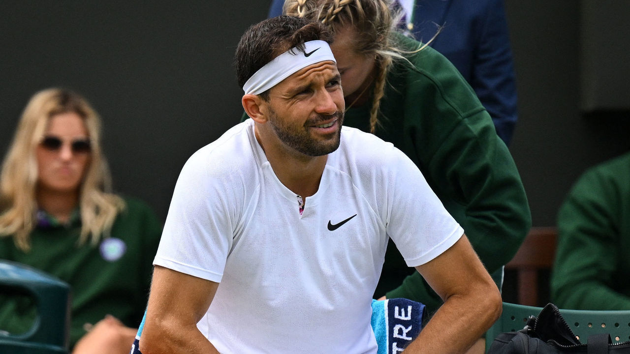 Bulgaria's Grigor Dimitrov sits on a chair as he reacts during his men's singles tennis match against US player Steve Johnson on the second day of the 2022 Wimbledon Championships at The All England Tennis Club in Wimbledon, southwest London, on June 28, 2022. - RESTRICTED TO EDITORIAL USE