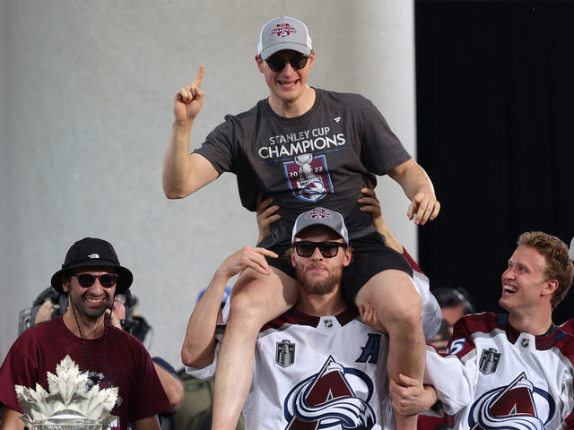 DENVER, COLORADO - JUNE 30: Cale Makar #8 of the Colorado Avalanche is lifted up by Mikko Rantanen #96 on-stage during the Colorado Avalanche Victory Parade and Rally at Civic Center Park on June 30, 2022 in Denver, Colorado.