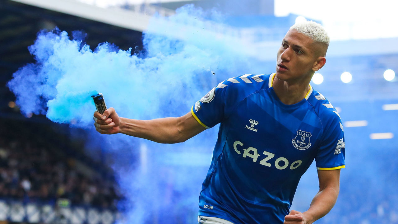 LIVERPOOL, ENGLAND - MAY 01: Richarlison of Everton picks up a lit flare as he celebrates scoring his side's first goal during the Premier League match between Everton and Chelsea at Goodison Park on May 01, 2022 in Liverpool, England.