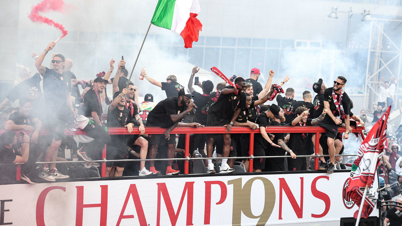 AC Milan players parade with the Scudetto Trophy on a double decker bus in front of the club's headquarters Casa Milan in Milan, on May 23, 2022 one day after AC Milan won the 2022 Italian Serie A "Scudetto" championship. - AC Milan won the Italian Serie A football match between Sassuolo and AC Milan, securing the "Scudetto" championship.