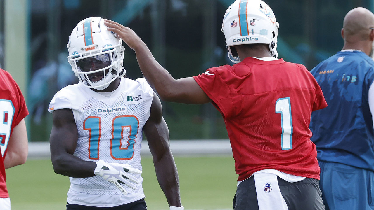 MIAMI GARDENS, FL - JUNE 1: Tua Tagovailoa #1 taps the helmet of Tyreek Hill #10 of the Miami Dolphins between drills during the Miami Dolphins Mandatory Minicamp at the Baptist Health Training Complex on June 1, 2022 in Miami Gardens, Florida.