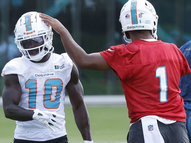 MIAMI GARDENS, FL - JUNE 1: Tua Tagovailoa #1 taps the helmet of Tyreek Hill #10 of the Miami Dolphins between drills during the Miami Dolphins Mandatory Minicamp at the Baptist Health Training Complex on June 1, 2022 in Miami Gardens, Florida.