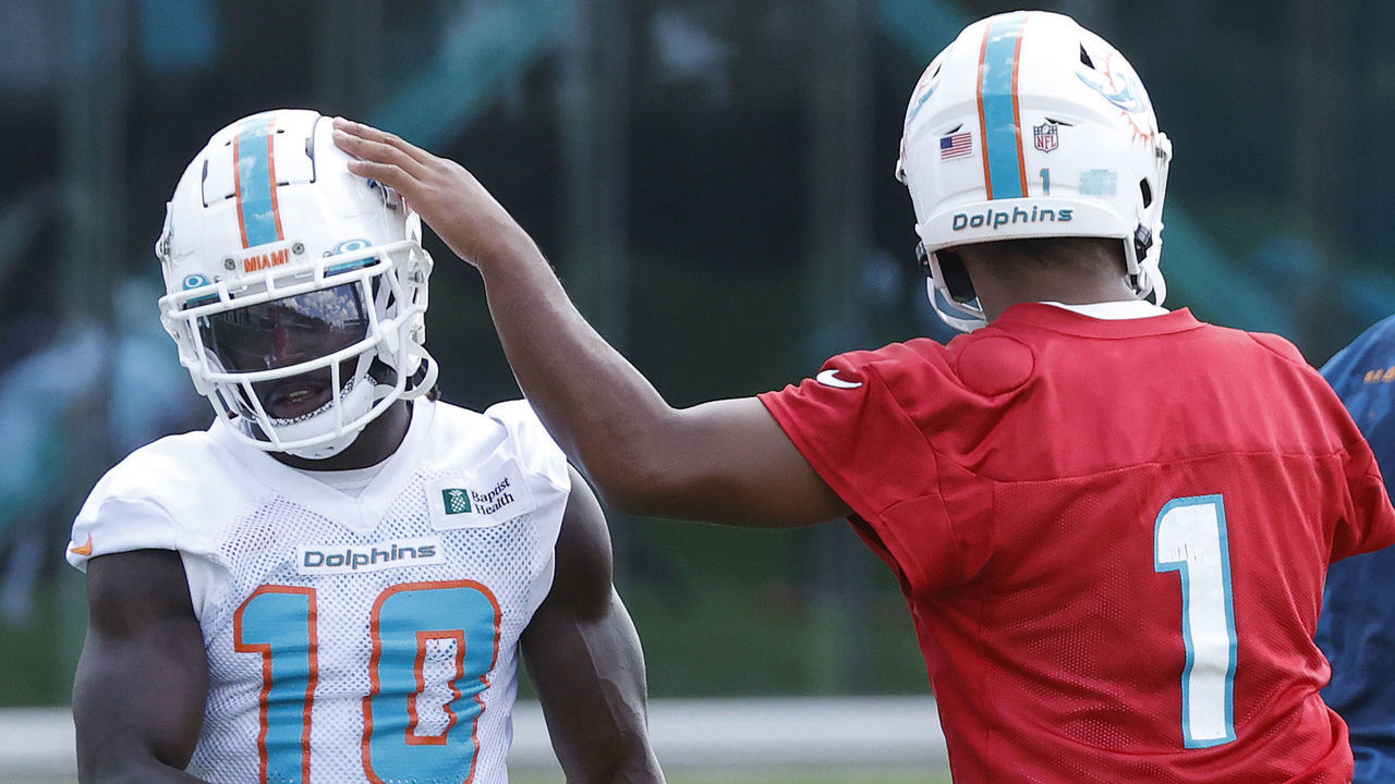 MIAMI GARDENS, FL - JUNE 1: Tua Tagovailoa #1 taps the helmet of Tyreek Hill #10 of the Miami Dolphins between drills during the Miami Dolphins Mandatory Minicamp at the Baptist Health Training Complex on June 1, 2022 in Miami Gardens, Florida.