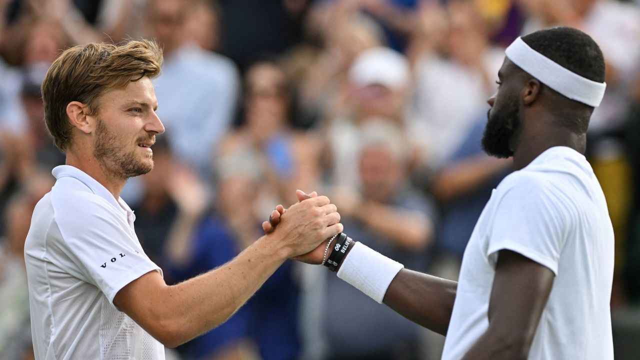 Belgium's David Goffin (L) shakes hands with US player Frances Tiafoe after winning their round of 16 men's singles tennis match on the seventh day of the 2022 Wimbledon Championships at The All England Tennis Club in Wimbledon, southwest London, on July 3, 2022. - RESTRICTED TO EDITORIAL USE