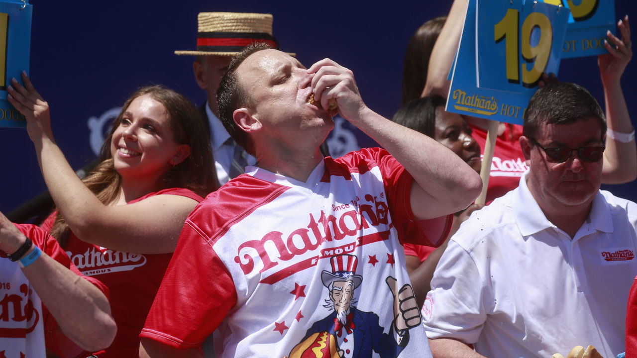 NEW YORK, NY - JULY 04: Joey Chestnut eats hot dogs during the 2022 Nathans Famous Fourth of July International Hot Dog Eating Contest on July 4, 2022 at Coney Island in the Brooklyn borough of New York City. The contest, which has happened every year since 1972, has returned in front of Nathan’s Famous on Surf Avenue this year.