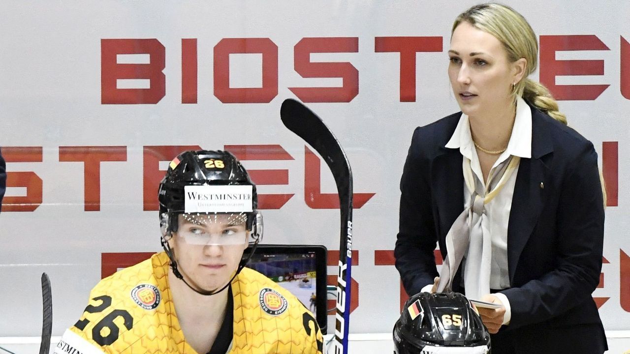 Germany's Finnish head coach Toni Soderholm (L) and Germany's Canadian assistant coach Jessica Campbell speak with players during the 2022 IIHF Ice Hockey World Championships preliminary round group A match between Germany and Italy in Helsinki, Finland, on May 20, 2022. - Finland OUT