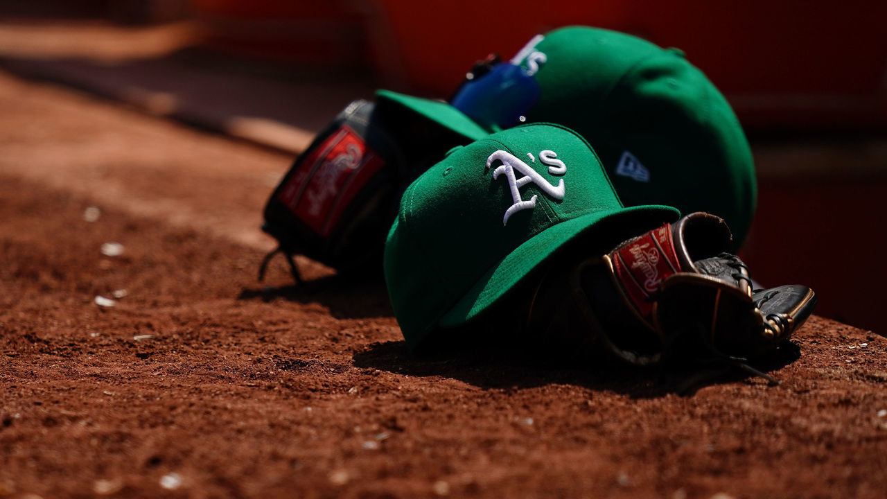 OAKLAND, CALIFORNIA - AUGUST 08: Oakland Athletics hats and gloves sit outside the dugout during the game against the Texas Rangers at RingCentral Coliseum on August 08, 2021 in Oakland, California.