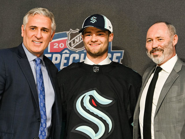 MONTREAL, QC - JULY 07: Seattle Kraken pick Shane Wright stands between management during the first round of the 2022 NHL Entry Draft on July 07, 2022 at Bell Centre in Montreal, QC
