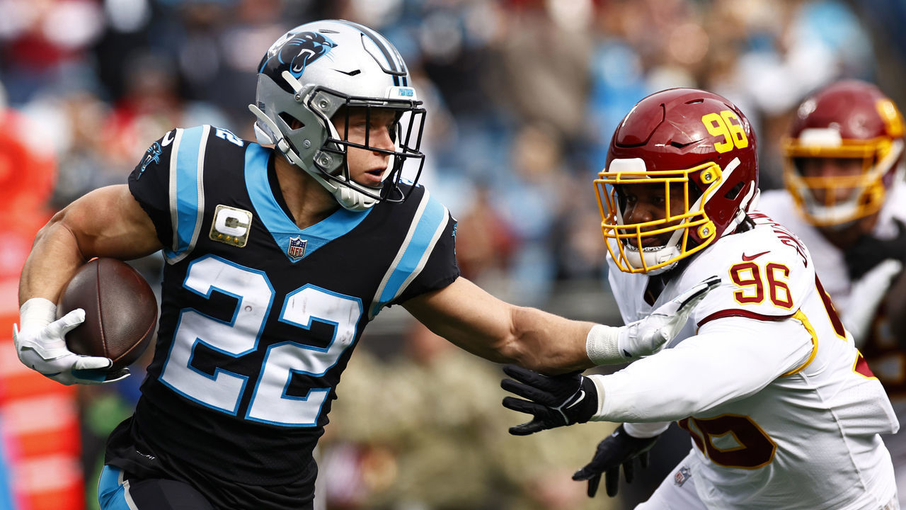 CHARLOTTE, NORTH CAROLINA - NOVEMBER 21: Christian McCaffrey #22 of the Carolina Panthers carries the ball against the defense of the Washington Football Team in the first quarter of the game at Bank of America Stadium on November 21, 2021 in Charlotte, North Carolina.