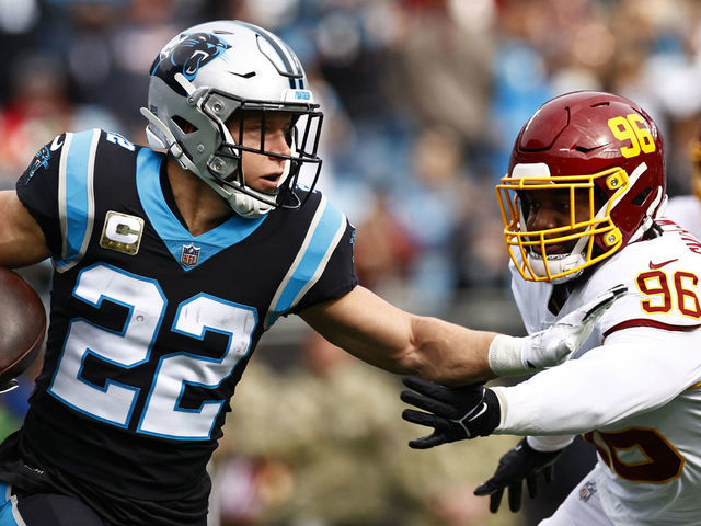 CHARLOTTE, NORTH CAROLINA - NOVEMBER 21: Christian McCaffrey #22 of the Carolina Panthers carries the ball against the defense of the Washington Football Team in the first quarter of the game at Bank of America Stadium on November 21, 2021 in Charlotte, North Carolina.