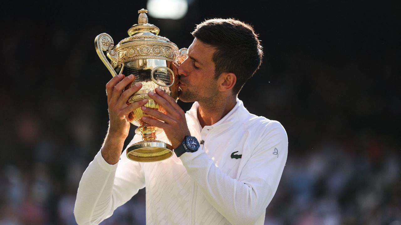 Serbia's Novak Djokovic kisses his trophy after defeating Australia's Nick Kyrgios during the men's singles final tennis match on the fourteenth day of the 2022 Wimbledon Championships at The All England Tennis Club in Wimbledon, southwest London, on July 10, 2022. - RESTRICTED TO EDITORIAL USE