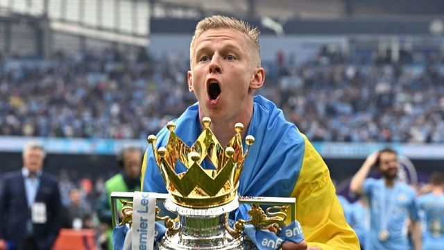 Manchester City's Ukrainian midfielder Oleksandr Zinchenko celebrates with the Premier league trophy on the pitch after the English Premier League football match between Manchester City and Aston Villa at the Etihad Stadium in Manchester, north west England, on May 22, 2022. - Manchester City won the Premier League for the fourth time in five seasons after a pulsating title race reached a dramatic conclusion as the champions staged an incredible comeback from two goals down to beat Aston Villa 3-2 on Sunday. - RESTRICTED TO EDITORIAL USE. No use with unauthorized audio, video, data, fixture lists, club/league logos or 'live' services. Online in-match use limited to 120 images. An additional 40 images may be used in extra time. No video emulation. Social media in-match use limited to 120 images. An additional 40 images may be used in extra time. No use in betting publications, games or single club/league/player publications.
