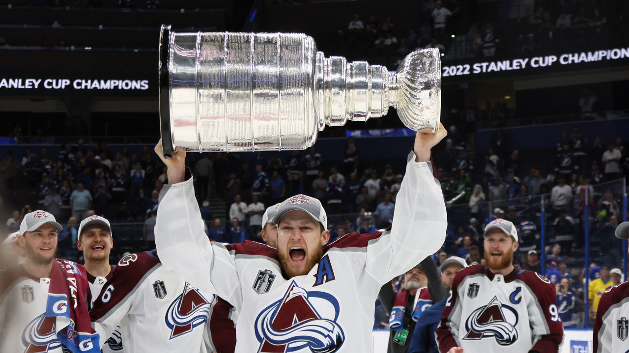 TAMPA, FLORIDA - JUNE 26: Nathan MacKinnon #29 of the Colorado Avalanche carries the Stanley Cup following the series winning victory over the Tampa Bay Lightning in Game Six of the 2022 NHL Stanley Cup Final at Amalie Arena on June 26, 2022 in Tampa, Florida.