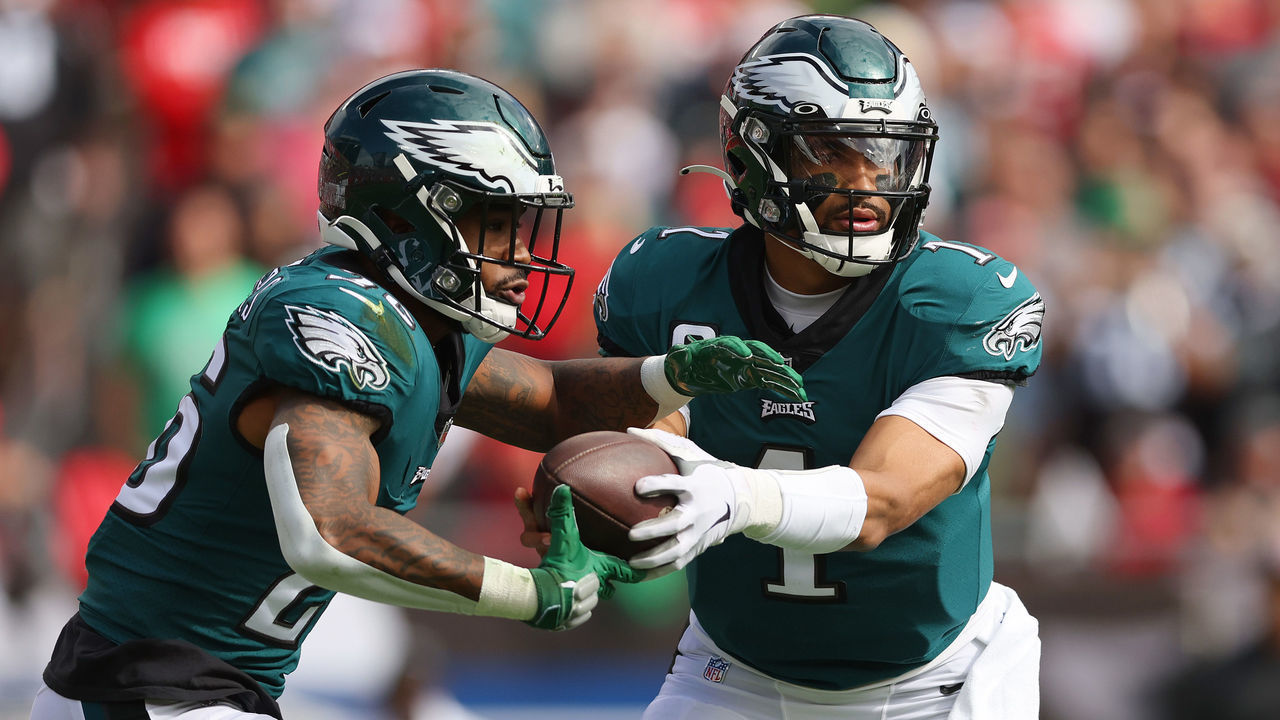 TAMPA, FLORIDA - JANUARY 16: Jalen Hurts #1 of the Philadelphia Eagles hands the ball off to Miles Sanders #26 against the Tampa Bay Buccaneers in the first half of the NFC Wild Card Playoff game at Raymond James Stadium on January 16, 2022 in Tampa, Florida.