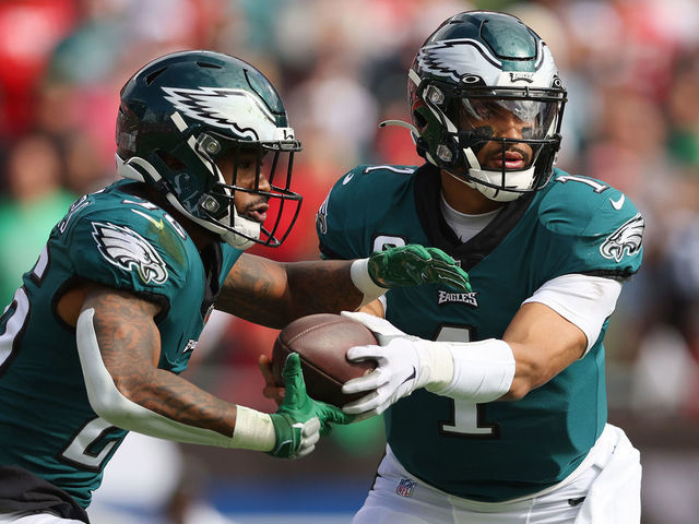 TAMPA, FLORIDA - JANUARY 16: Jalen Hurts #1 of the Philadelphia Eagles hands the ball off to Miles Sanders #26 against the Tampa Bay Buccaneers in the first half of the NFC Wild Card Playoff game at Raymond James Stadium on January 16, 2022 in Tampa, Florida.