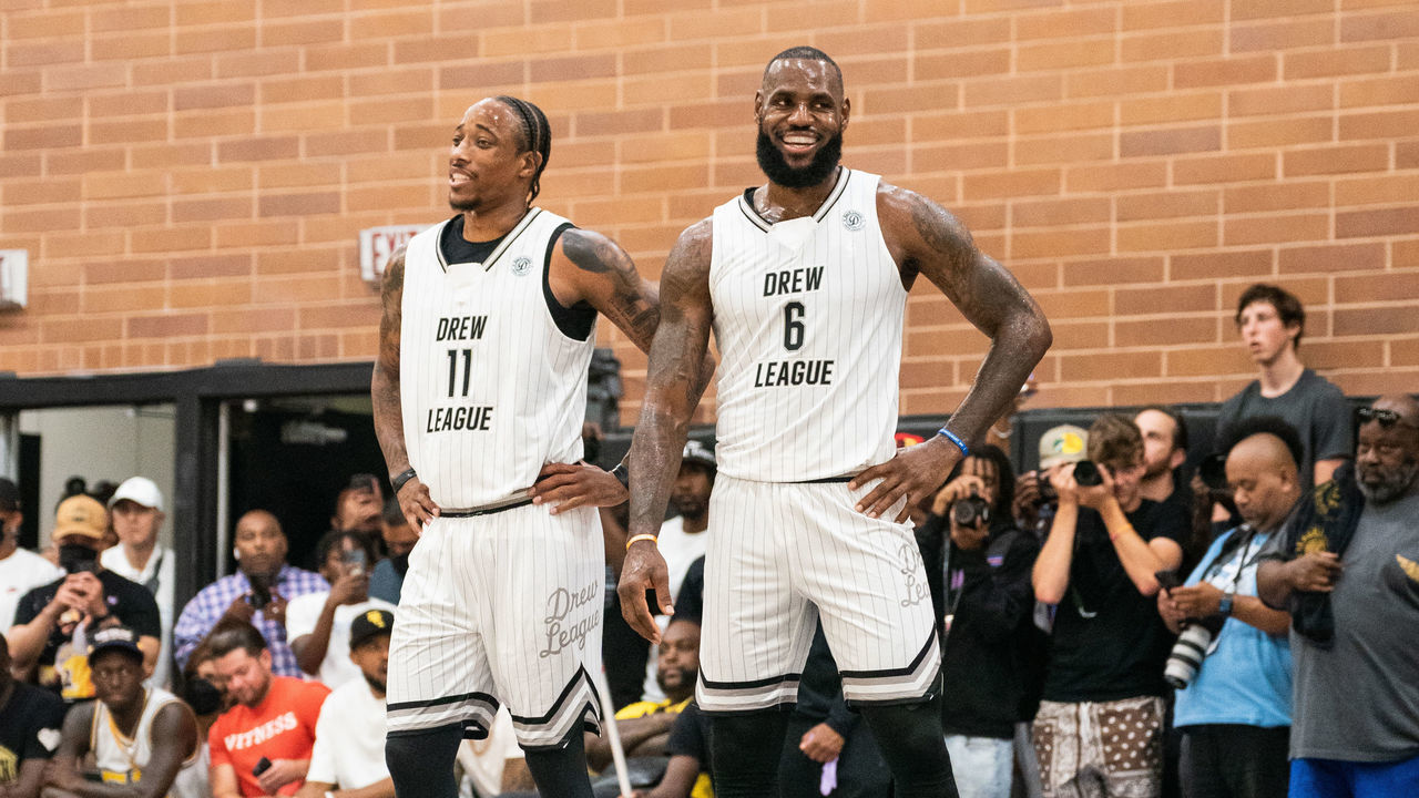 LOS ANGELES, CALIFORNIA - JULY 16: DeMar DeRozan and LeBron James smile on the court during the Drew League Pro-Am on July 16, 2022 in Los Angeles, California.