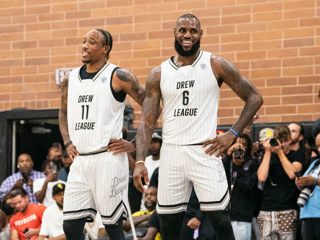 LOS ANGELES, CALIFORNIA - JULY 16: DeMar DeRozan and LeBron James smile on the court during the Drew League Pro-Am on July 16, 2022 in Los Angeles, California.