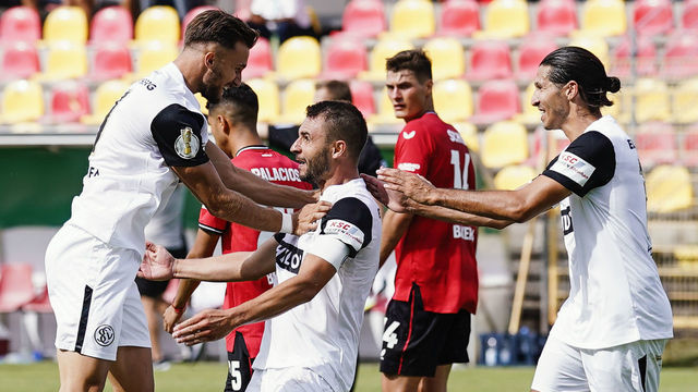30 July 2022, Saarland, Spiesen-Elversberg: Soccer: DFB Cup, SV Elversberg - Bayer Leverkusen, 1st round, Ursapharm Arena an der Kaiserlinde. Goal scorer Kevin Conrad (M) of Elversberg celebrates with Valdrin Mustafa (l) of Elversberg and Marcel Correia of Elversberg over the goal for 4:2. Photo: Uwe Anspach/dpa - IMPORTANT NOTE: In accordance with the requirements of the DFL Deutsche Fußball Liga and the DFB Deutscher Fußball-Bund, it is prohibited to use or have used photographs taken in the stadium and/or of the match in the form of sequence pictures and/or video-like photo series.