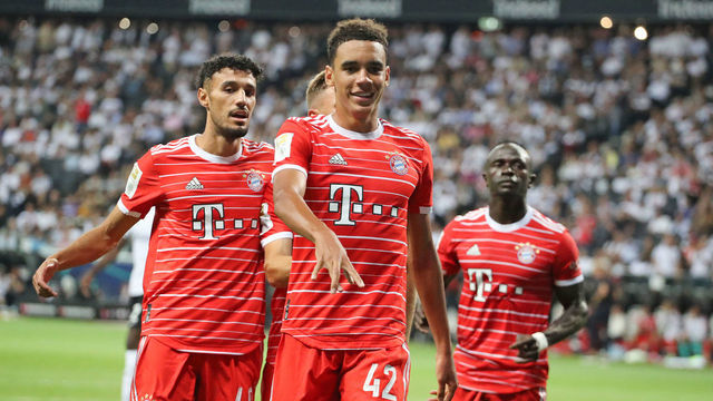 FRANKFURT AM MAIN, GERMANY - AUGUST 05: Jamal Musiala of Bayern Muenchen celebrates as he scores the goal with Noussair Mazraoui of FC Bayern Muenchen Sadio Mane of Bayern Muenchen during the Bundesliga match between Eintracht Frankfurt and FC Bayern München at Deutsche Bank Park on August 05, 2022 in Frankfurt am Main, Germany.