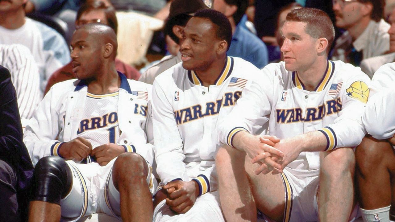 OAKLAND, CA - 1989: (L) Tim Hardaway #10, (C) Mitch Richmond #23 and (R) Chris Mullin #17 of the Golden State Warriors sit on the bench during a game played in 1989 at the Oakland-Alameda Coliseum in Oakland, California. NOTE TO USER: User expressly acknowledges that, by downloading and or using this photograph, User is consenting to the terms and conditions of the Getty Images License agreement. Mandatory Copyright Notice: Copyright 1989 NBAE