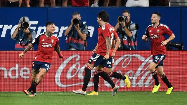 Osasuna's Argentinian forward Ezequiel "Chimy" Avila (L) celebrates with teammates after scoring his team's first goal during the Spanish league football match between CA Osasuna and Sevilla FC at El Sadar stadium in Pamplona on August 12, 2022.