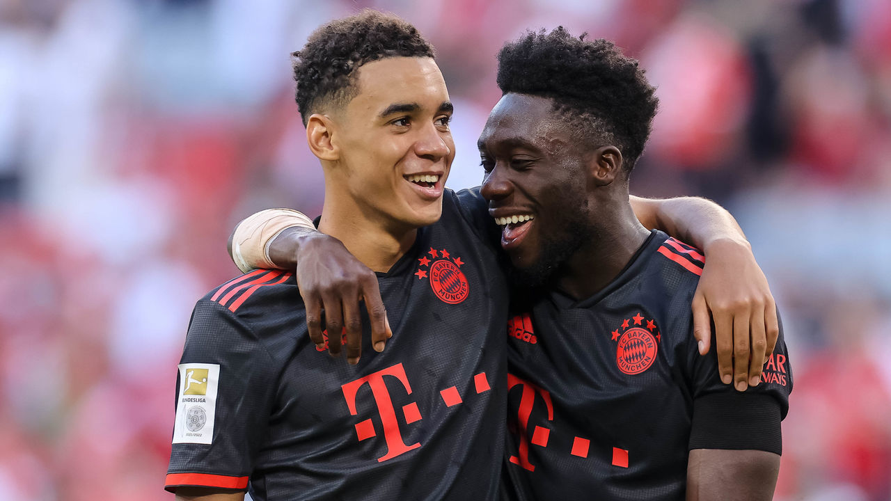 MUNICH, GERMANY - AUGUST 14: Jamal Musiala of Bayern Muenchen and Alphonso Davies of Bayern Muenchen look on during the Bundesliga match between FC Bayern München and VfL Wolfsburg at Allianz Arena on August 14, 2022 in Munich, Germany.