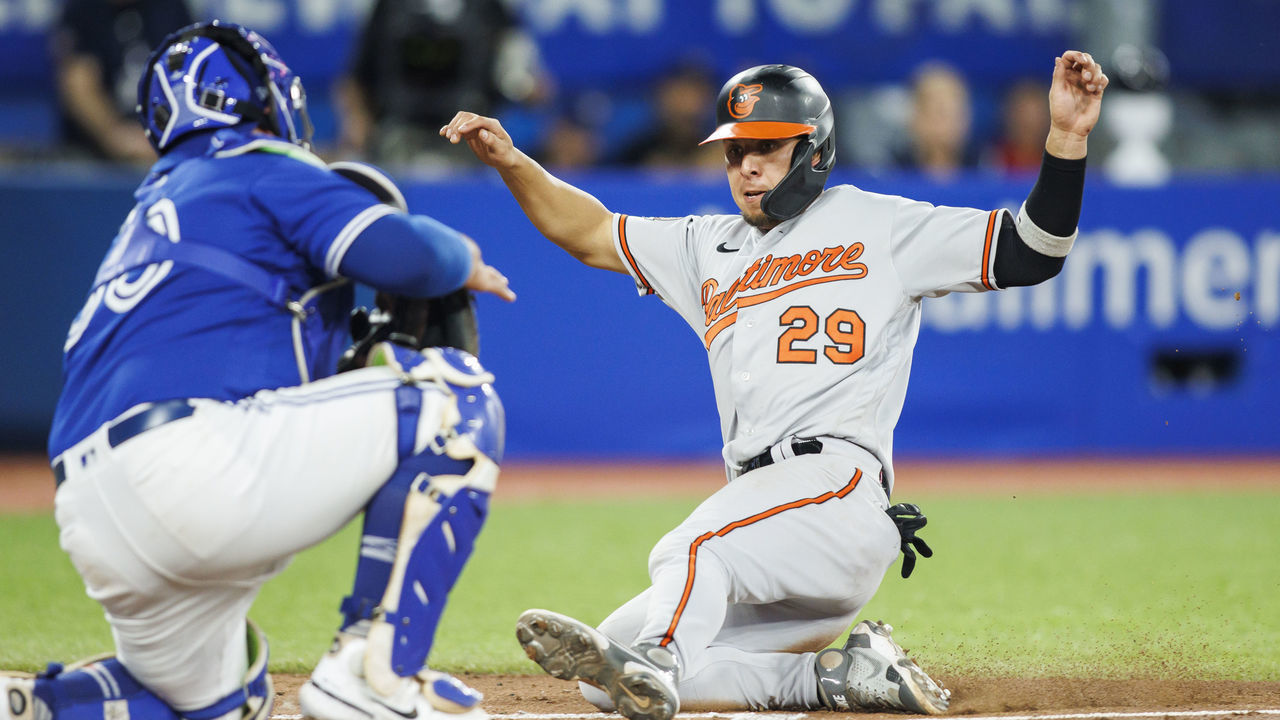 TORONTO, ON - AUGUST 16: Ramon Urias #29 of the Baltimore Orioles slides home safe to score on a Ryan McKenna #26 single in the sixth inning of their MLB game against the Toronto Blue Jays at Rogers Centre on August 16, 2022 in Toronto, Canada.
