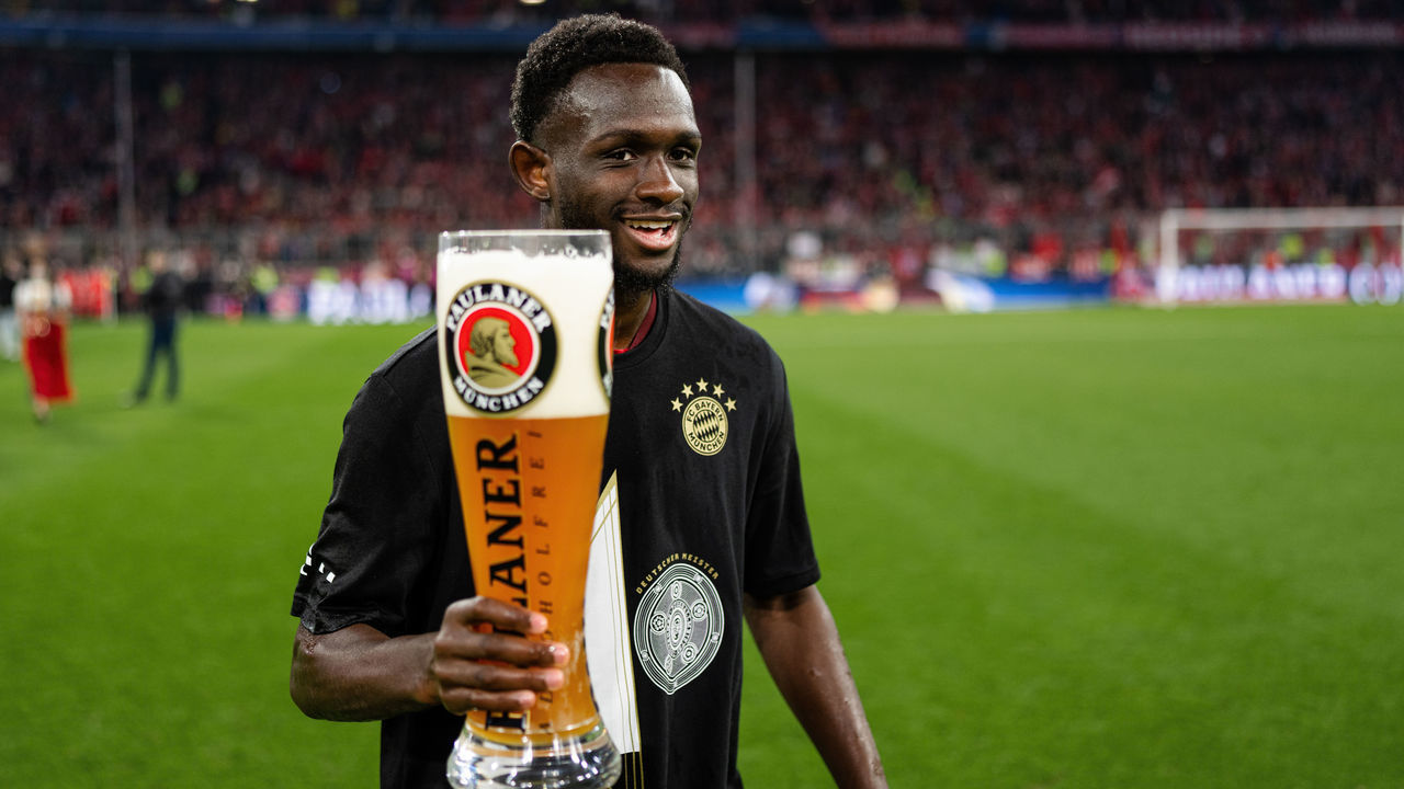 MUNICH, GERMANY - APRIL 23: Tanguy Nianzou of FC Bayern Muenchen with a beer glas while celebrating the win of the 10th german championship in a row after the Bundesliga match between FC Bayern München and Borussia Dortmund at Allianz Arena on April 23, 2022 in Munich, Germany.