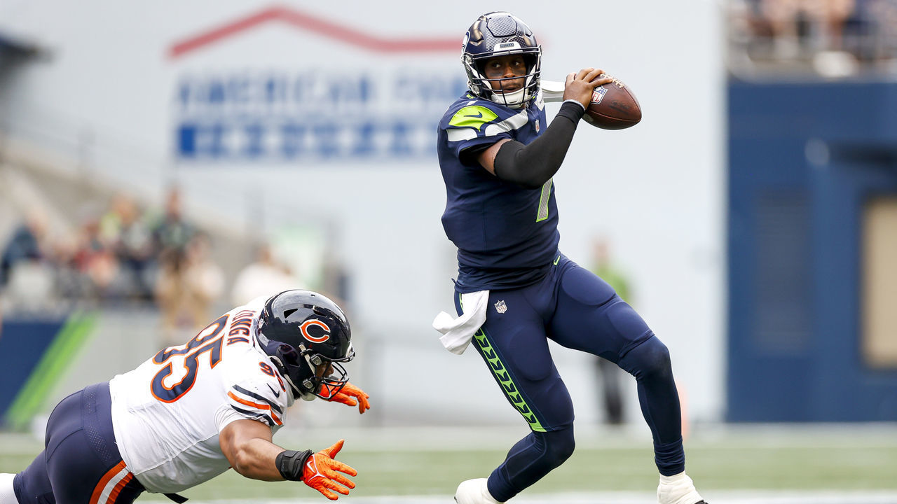 SEATTLE, WASHINGTON - AUGUST 18: Geno Smith #7 of the Seattle Seahawks breaks the tackle of Khyiris Tonga #95 of the Chicago Bears in the second quarter during the preseason game at Lumen Field on August 18, 2022 in Seattle, Washington.