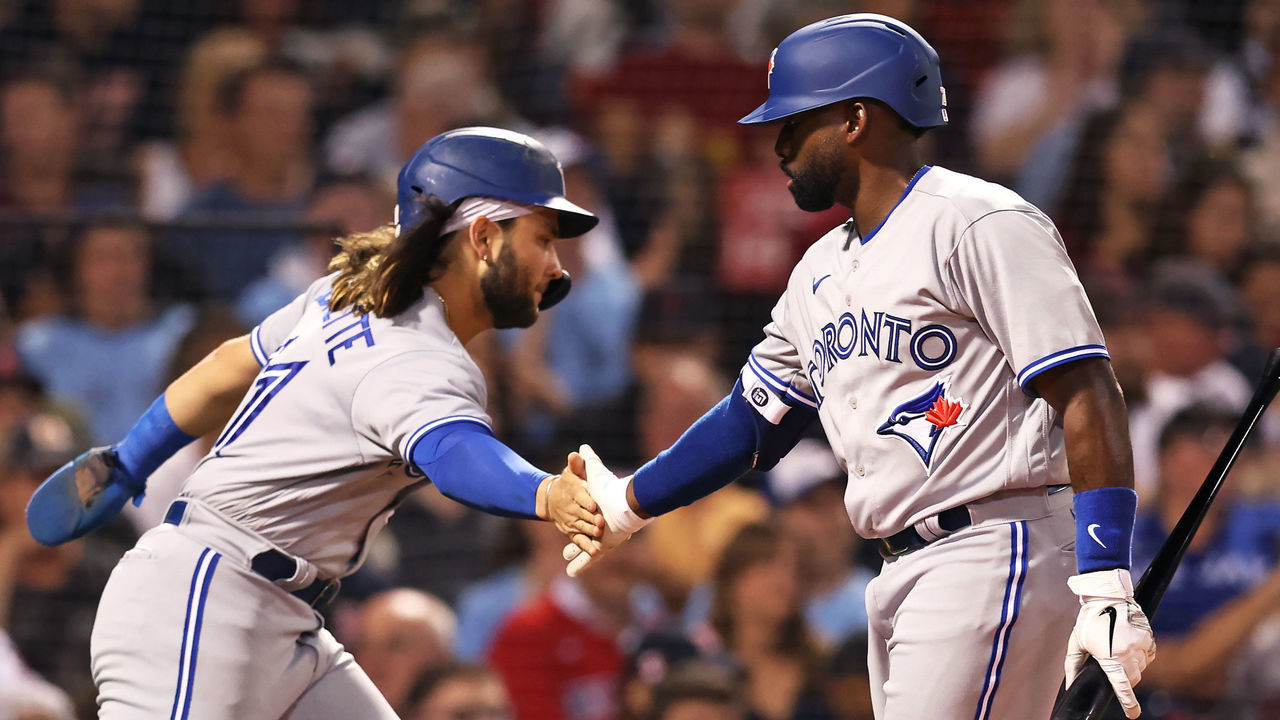 BOSTON, MASSACHUSETTS - AUGUST 23: Bo Bichette #11 of the Toronto Blue Jays celebrates with Jackie Bradley Jr. #25 after scoring a run against the Boston Red Sox during the third inning at Fenway Park on August 23, 2022 in Boston, Massachusetts.