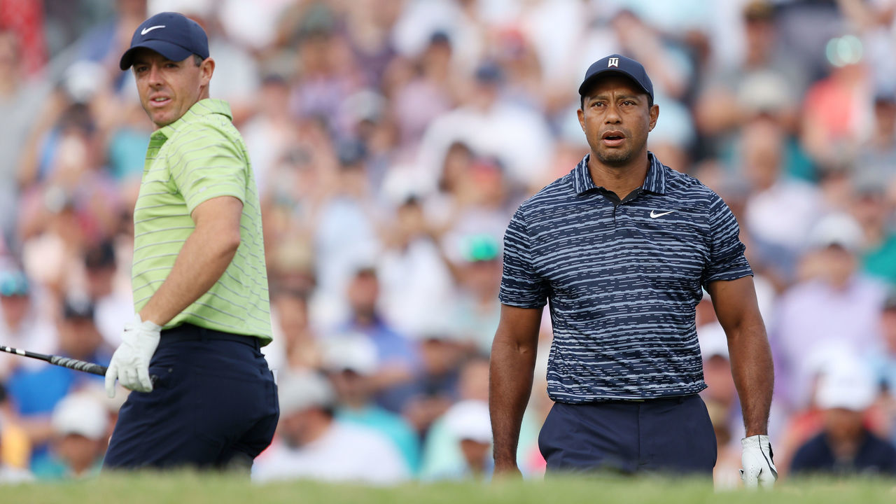 TULSA, OKLAHOMA - MAY 19: Tiger Woods of the United States walks from the first tee as Rory McIlroy of Northern Ireland looks on during the first round of the 2022 PGA Championship at Southern Hills Country Club on May 19, 2022 in Tulsa, Oklahoma.
