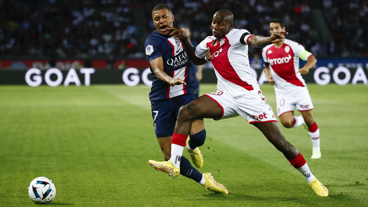 PARIS, FRANCE - AUGUST 28: Mohamed Camara #4 of AS Monaco challenges Kylian Mbappe #7 of Paris Saint-Germain during the Ligue 1 match between Paris Saint-Germain and AS Monaco at Parc des Princes on August 28, 2022 in Paris, France.